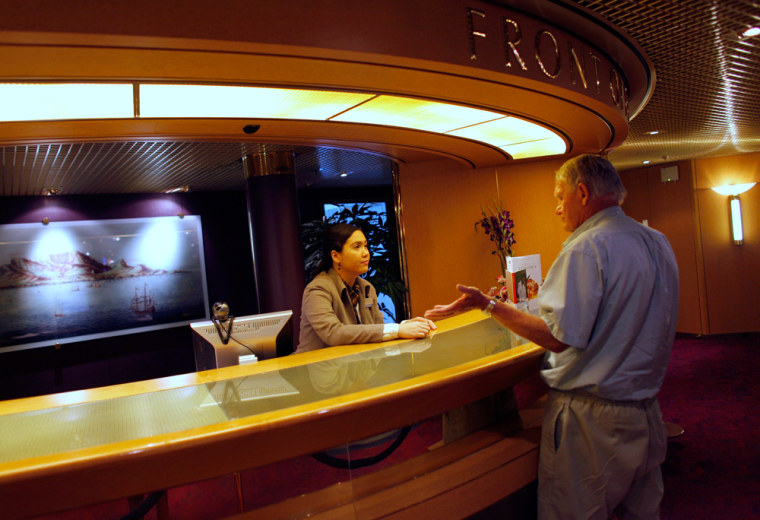 Image: A passenger talks with a member of the crew on the Eurodam cruise ship at Port Everglades in Fort Lauderdale, FL.